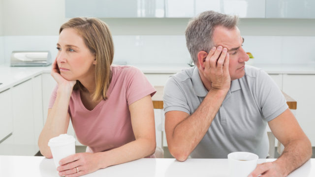 Unhappy couple not talking after an argument in the kitchen at home