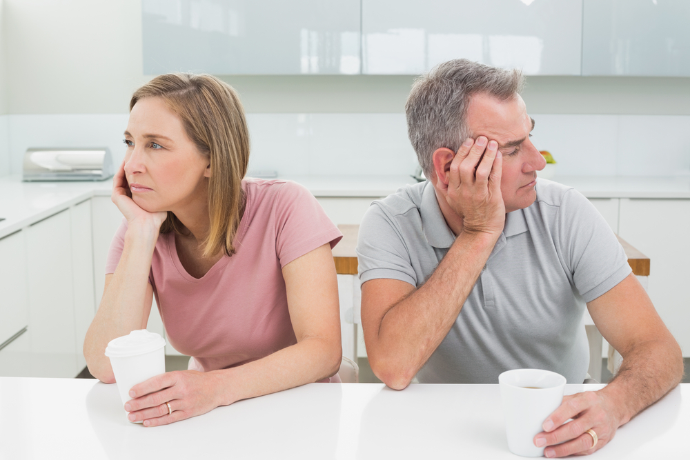 Unhappy couple not talking after an argument in the kitchen at home