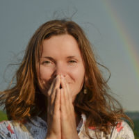 Grateful woman in front of rainbow