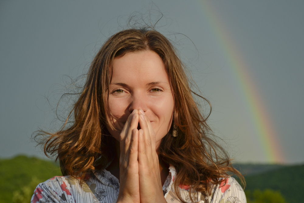 Grateful woman in front of rainbow