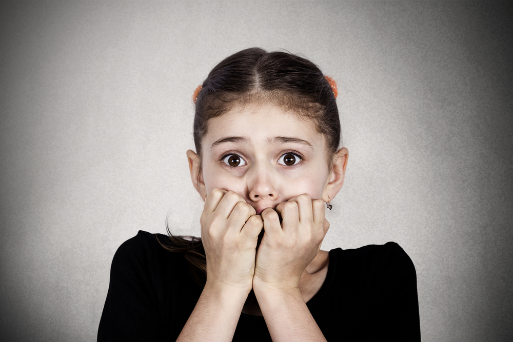 Fearful anxious girl biting nails